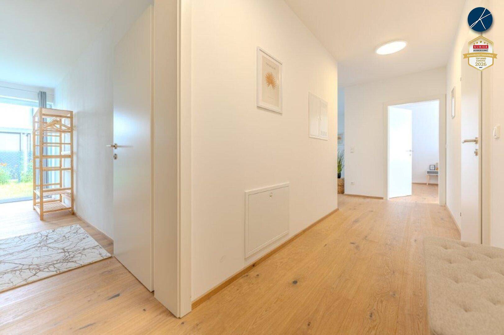Heller Flur mit Holzboden und Zugang zu verschiedenen Räumen der Wohnung.