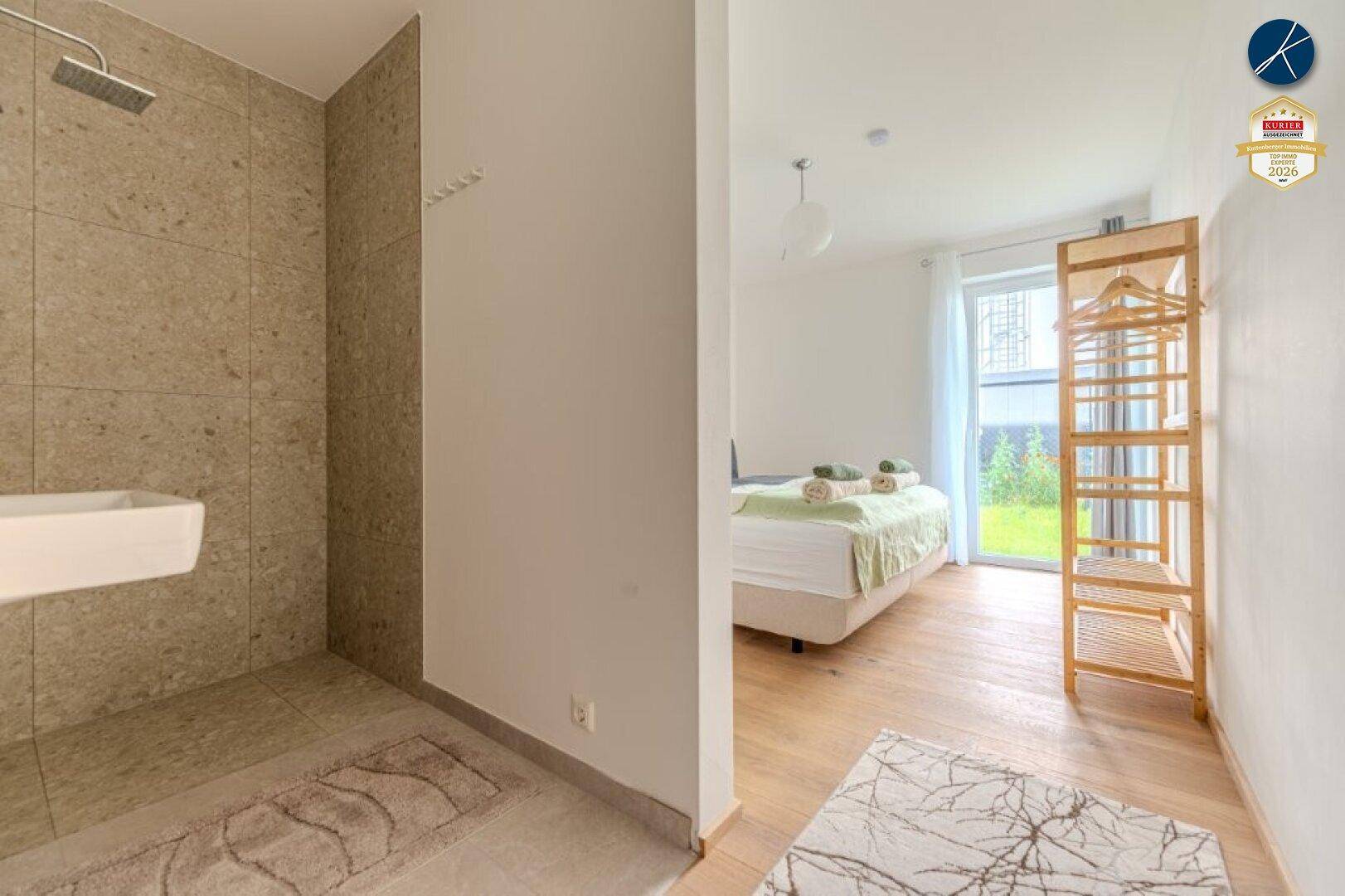 Übergangsbereich zwischen Schlafzimmer und Duschbereich mit Holzboden.