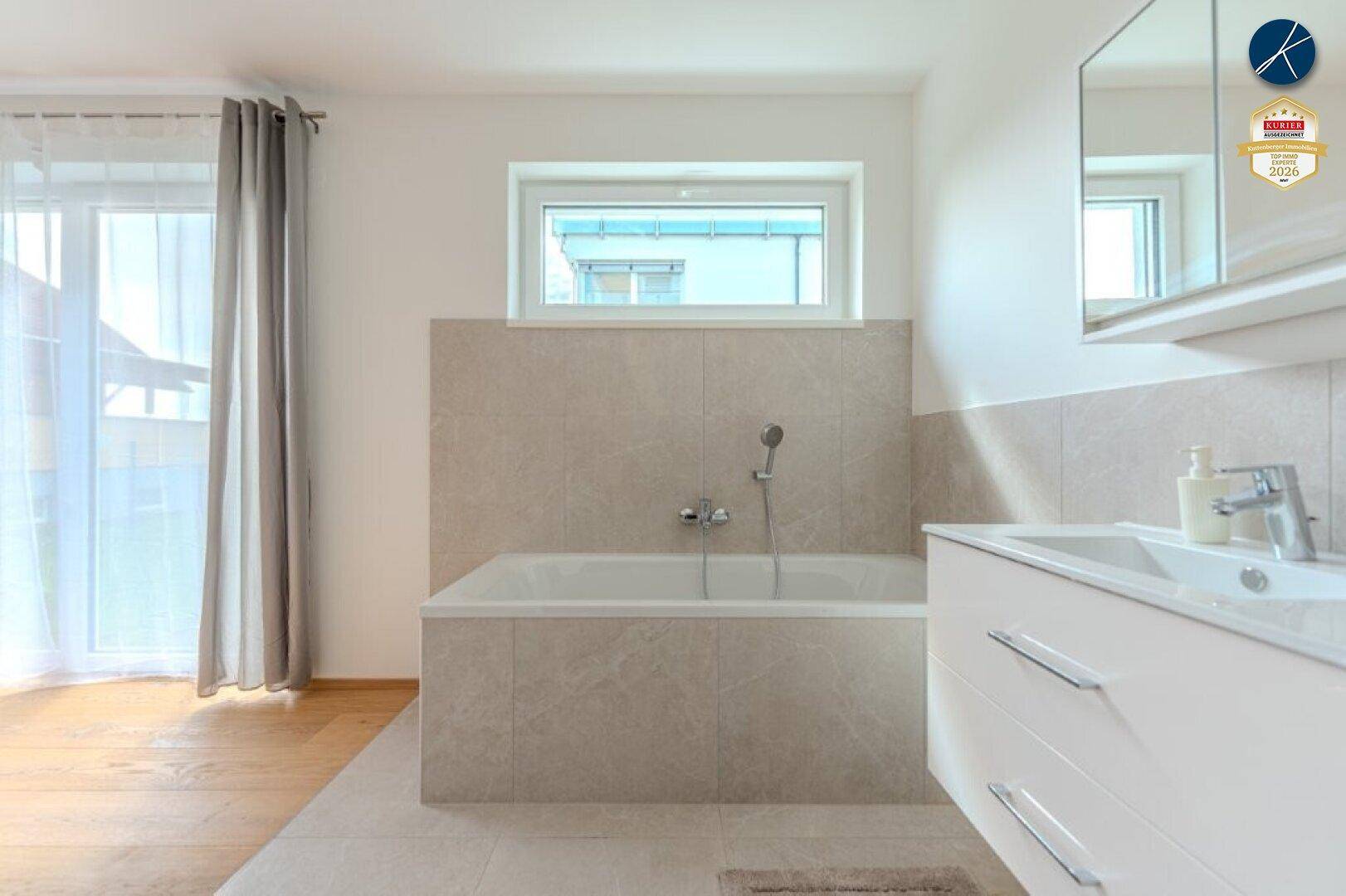 Modernes Badezimmer mit Badewanne, Einzelwaschbecken und Fenster für Tageslicht.