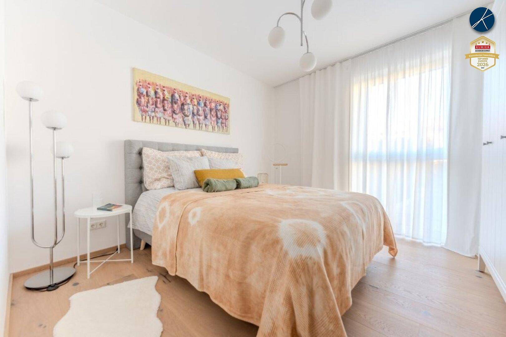 Helles Schlafzimmer mit Doppelbett, modernen Nachttischen und großen Fenstern für viel Tageslicht.
