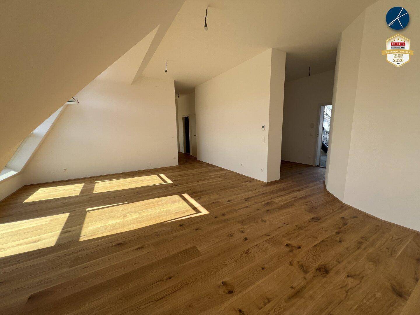 Geräumiger Flur mit Holzboden und Zugang zu mehreren Zimmern im Dachgeschoss.
