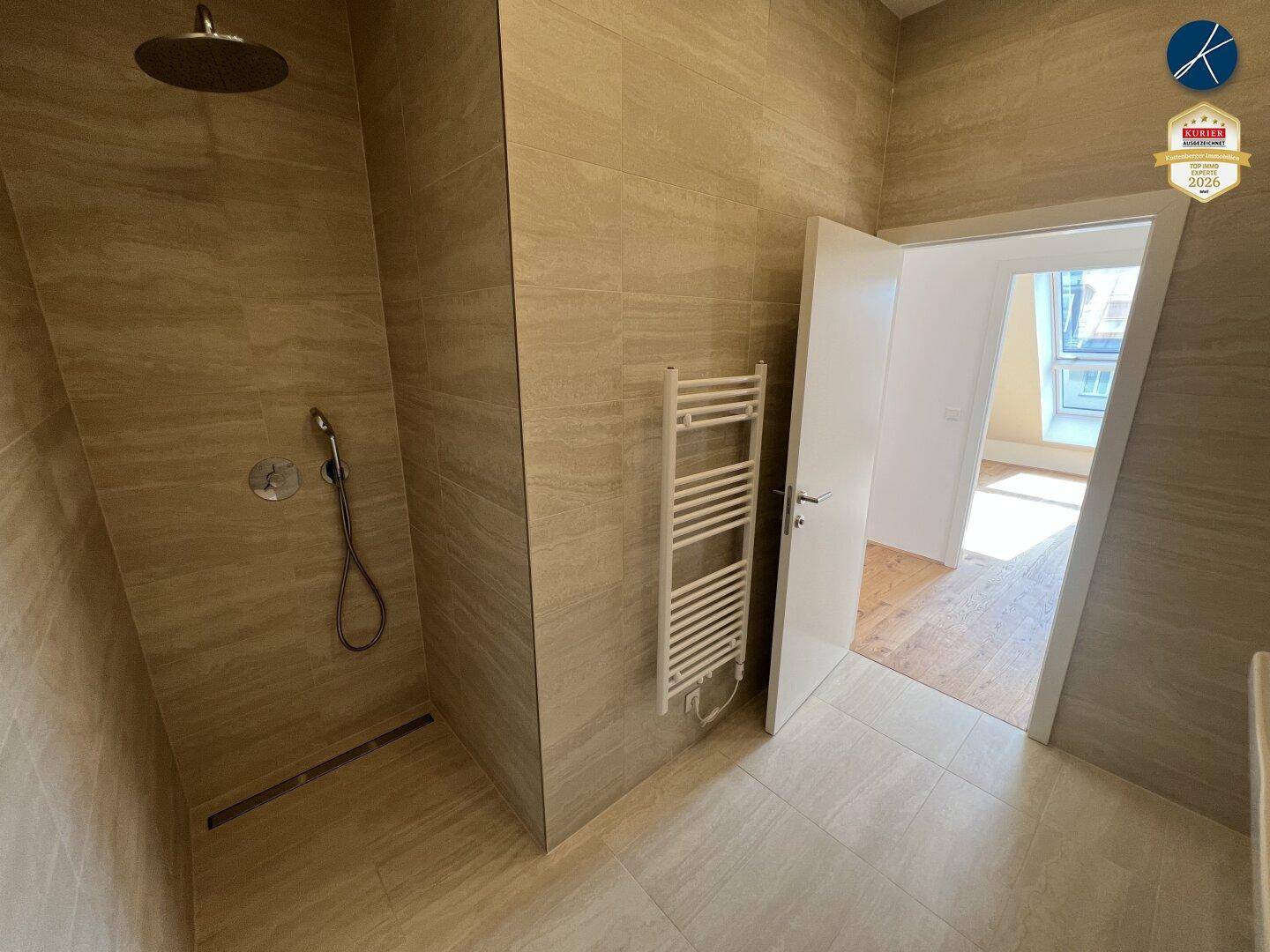Modernes Badezimmer mit begehbarer Dusche, beigefarbenen Fliesen und Handtuchheizkörper.
