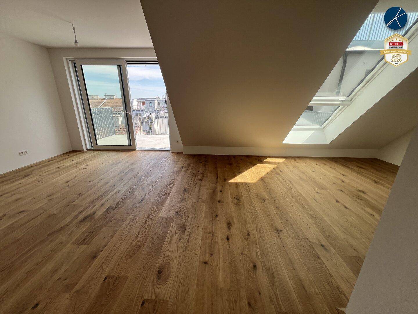Helles Wohnzimmer mit hochwertigem Holzparkett, großen Fenstern und Zugang zu einem Balkon.
