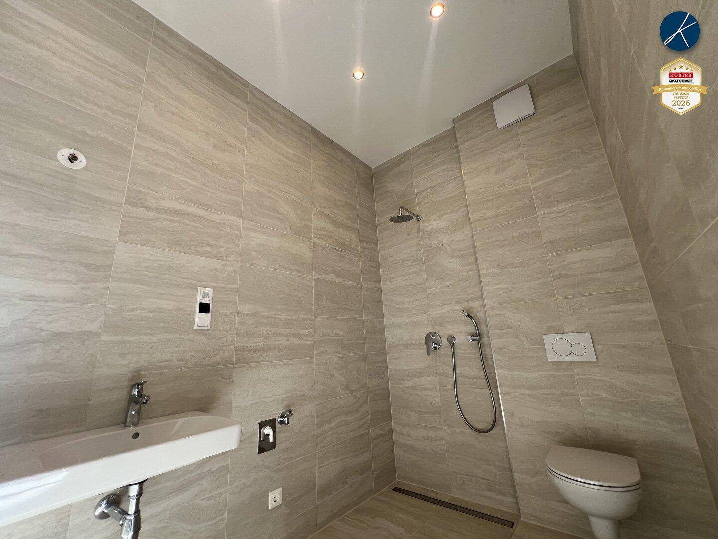 Modernes Badezimmer mit begehbarer Dusche, Wand-WC und eleganten Fliesen.