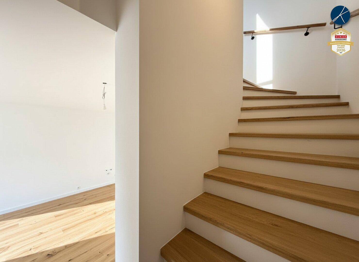 Heller Treppenaufgang mit Holzstufen und weiß gestrichenen Wänden in modernem Design.