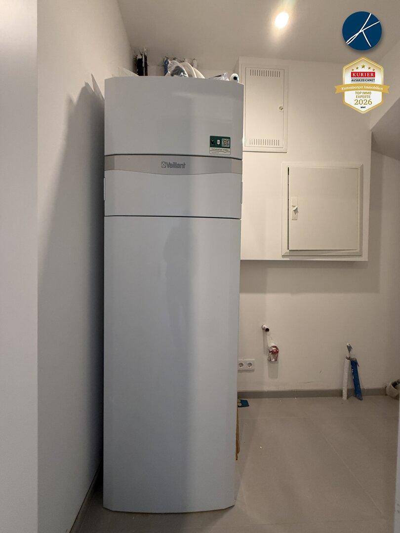 Technikraum mit moderner Wärmepumpe oder Warmwasserspeicher und Wartungszugängen.