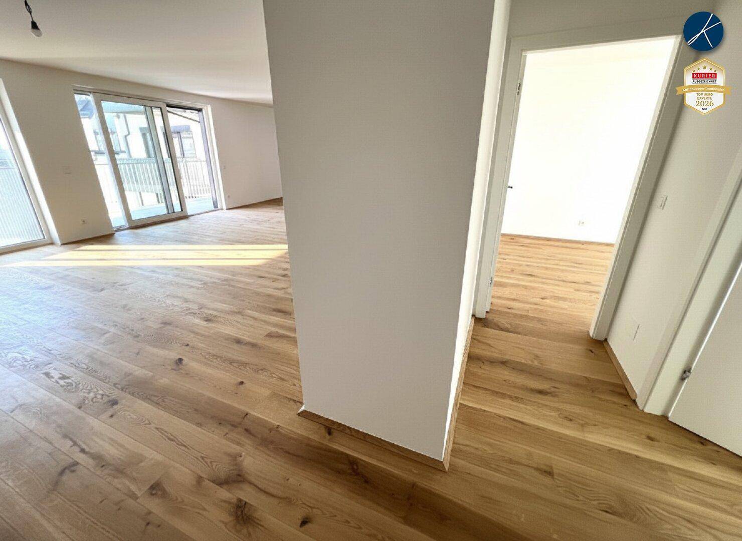 Heller Flur mit Holzboden und Zugang zu weiteren Zimmern in der modernen Wohnung.