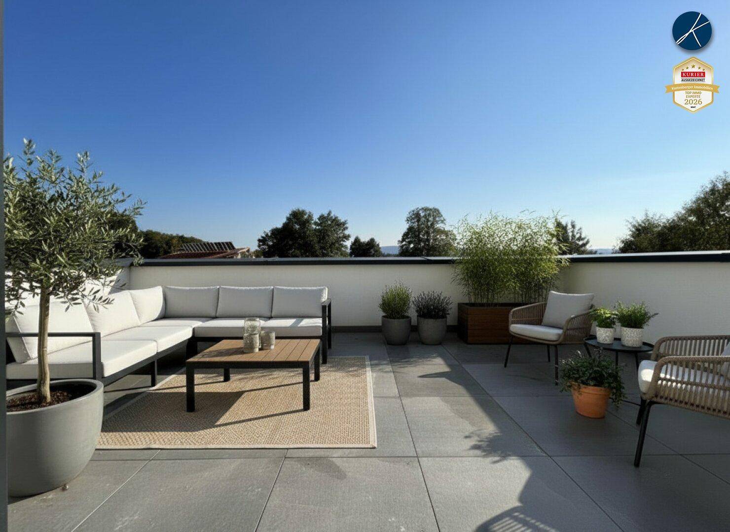 Möblierte Dachterrasse mit bequemen Lounge-Möbeln, Pflanzen und einem schönen Ausblick ins Grüne.