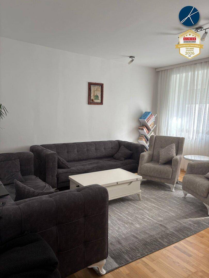 Gemütliches Wohnzimmer mit bequemen Sofas, Sesseln und Holzboden.