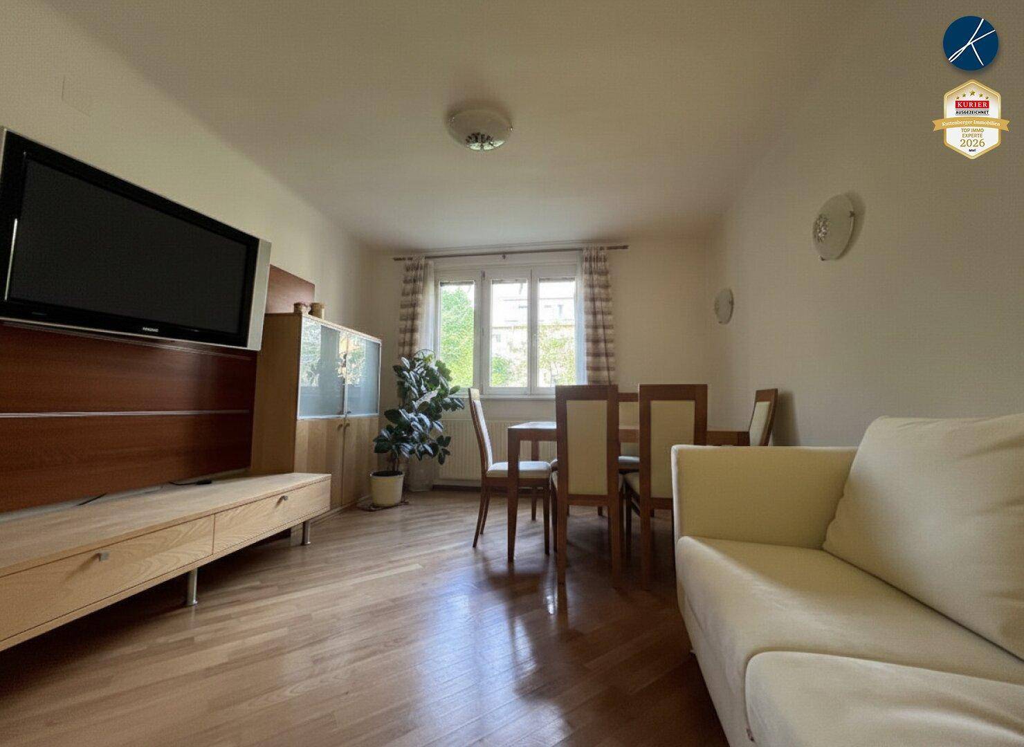 Heller Wohn-Essbereich mit Holzboden, Esstisch und Sofa, ideal für gesellige Stunden.