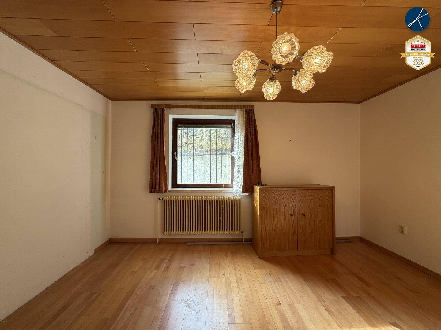 Helles Zimmer mit Parkettboden, Holzdecke und Fenster, ideal als Schlaf- oder Arbeitszimmer.