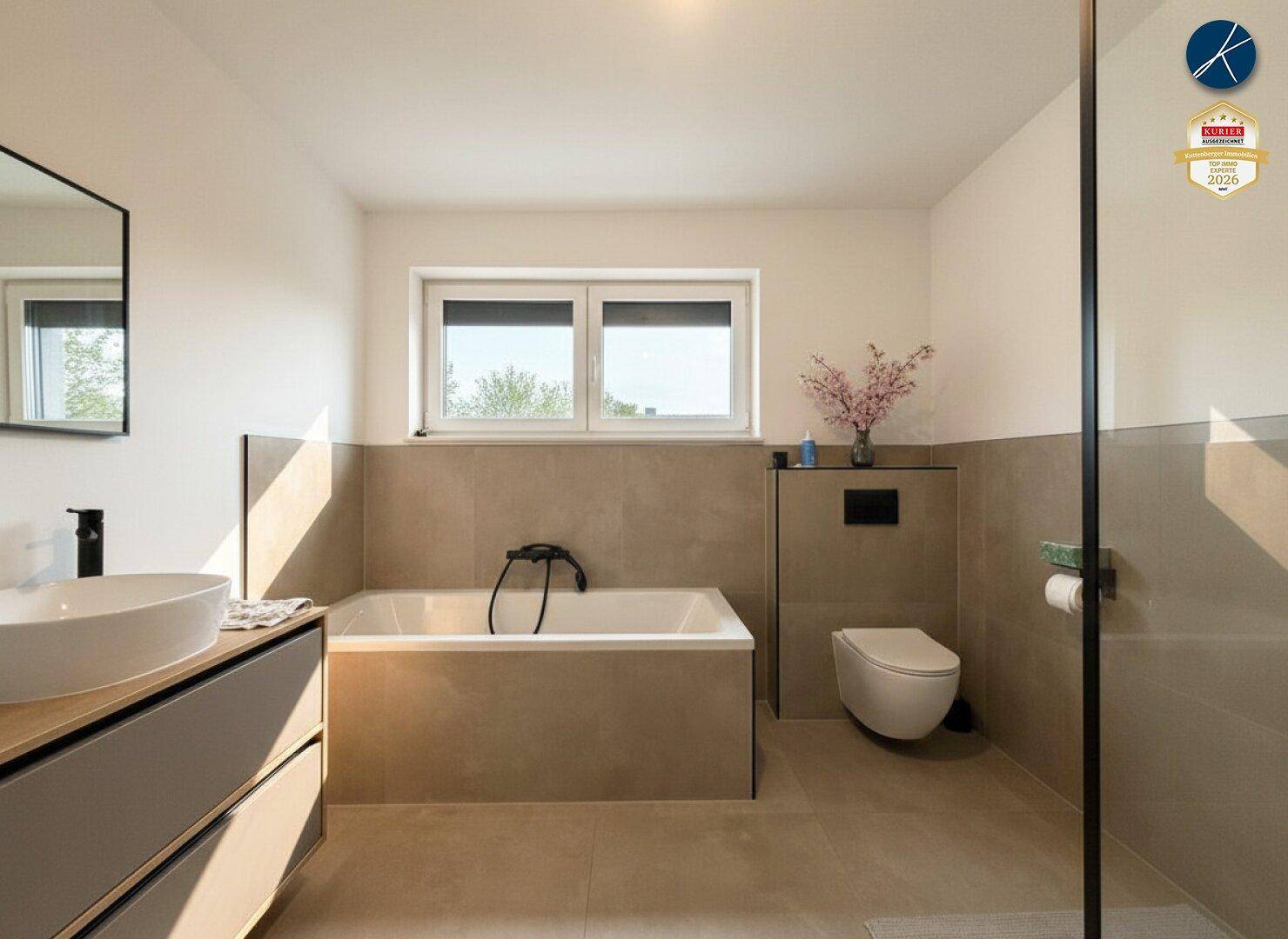 Modernes Badezimmer mit Badewanne, Dusche, Waschtisch und Fenster für Tageslicht.