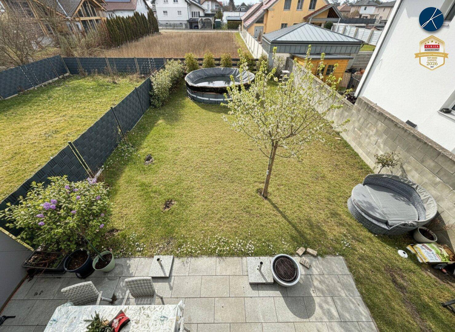 Gartenbereich von oben gesehen mit Rasenfläche, Terrasse und einem Aufstellpool.