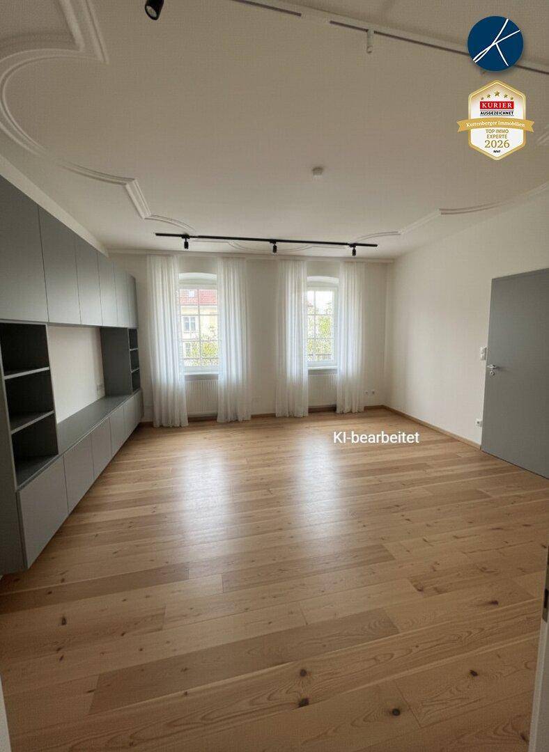Helles Wohnzimmer mit Holzboden, dekorativer Stuckdecke und modernen Einbauschränken.