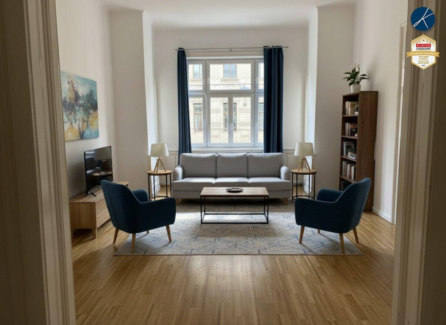 Gemütliches Wohnzimmer mit Sofa, Sesseln und einem großen Fenster, das viel Licht spendet.