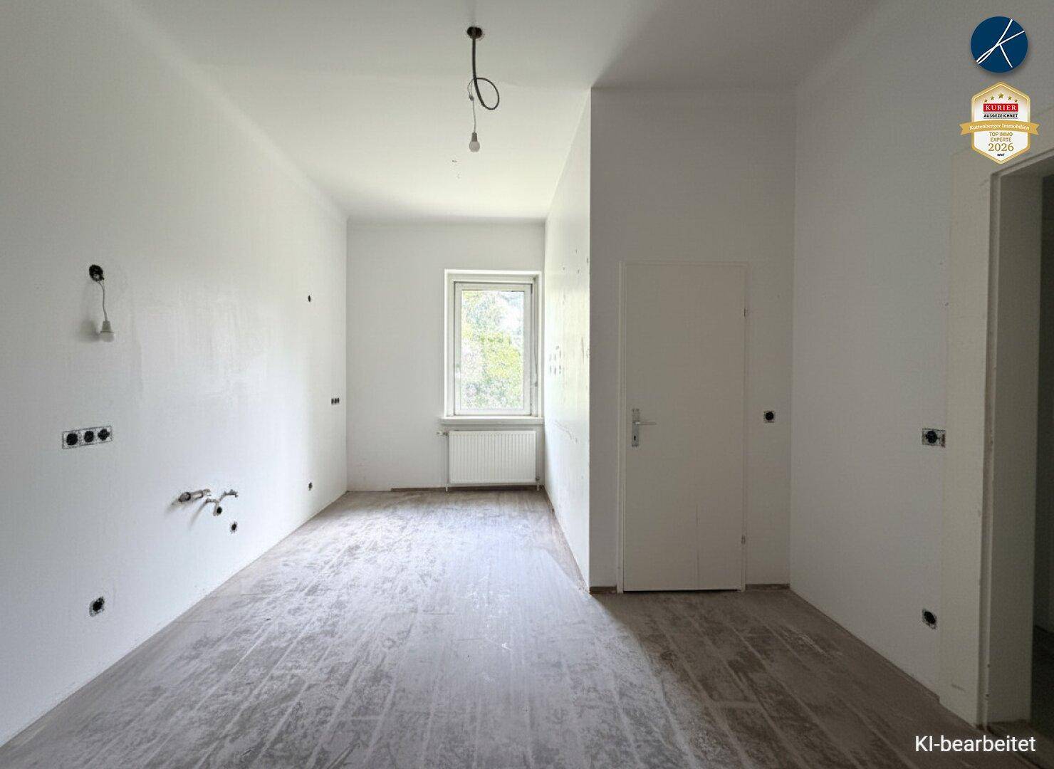 Leerer Raum mit sichtbaren Elektroinstallationen und einem Fenster, bereit für den Ausbau.