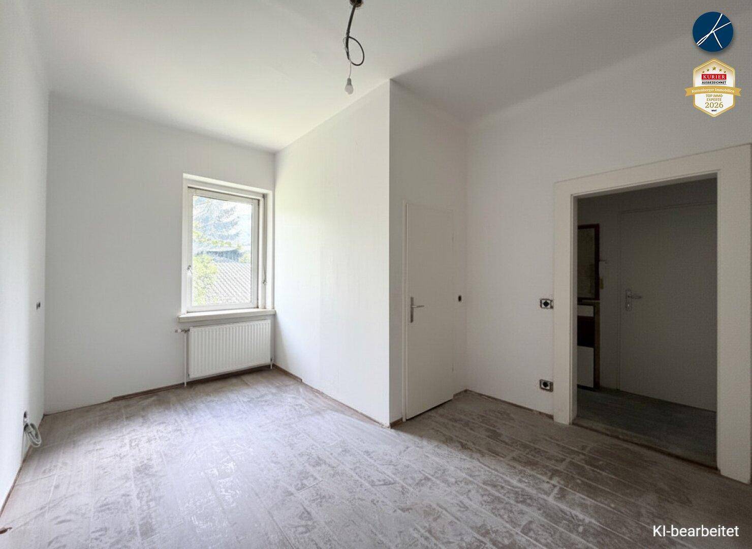 Unmöblierter Raum mit einem Fenster und vorbereiteten Anschlüssen für zukünftige Nutzung.