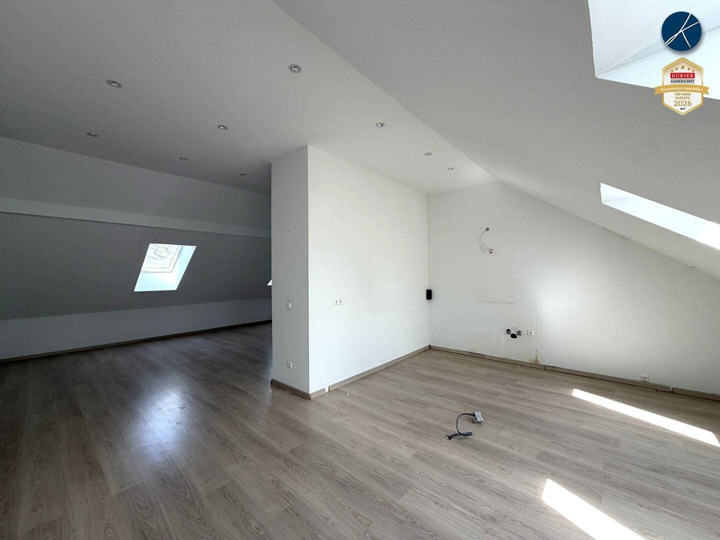 Geräumiger Dachbodenbereich mit Laminatboden und schrägen Wänden, ideal für individuelle Gestaltungsmöglichkeiten.