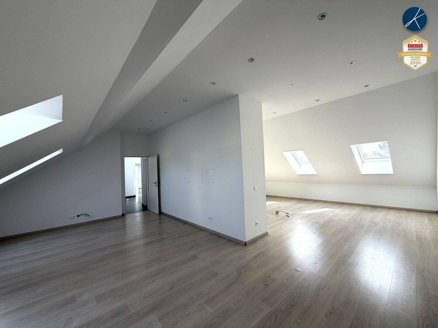 Großer, heller Dachbodenraum mit mehreren Dachfenstern und Laminatboden, bietet viel Potenzial.