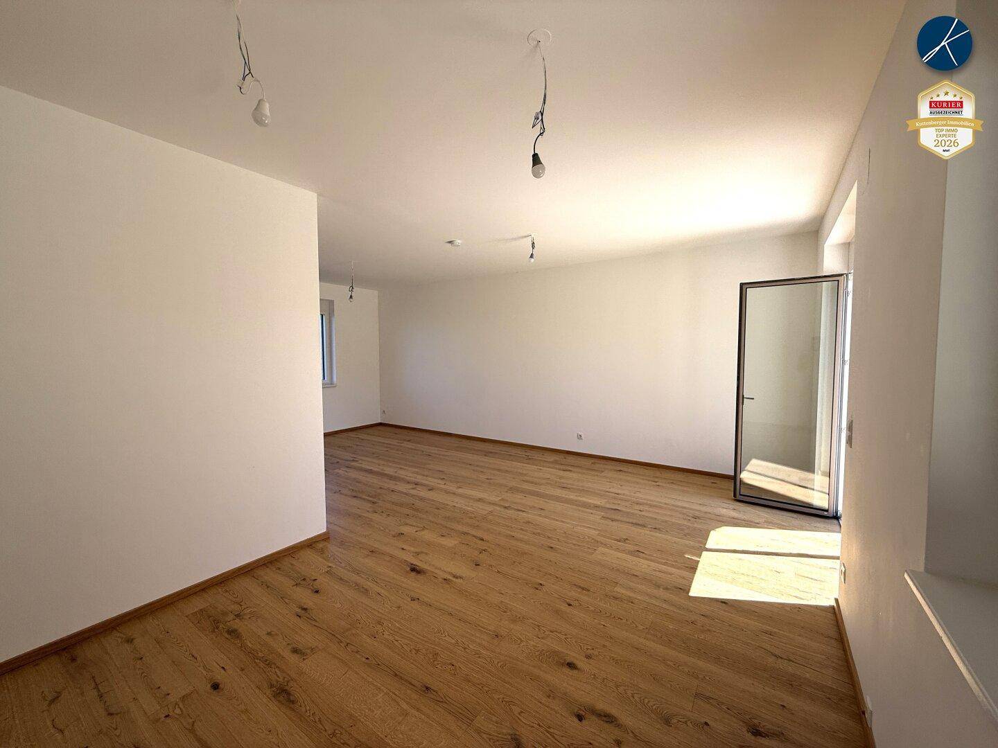Geräumiges, helles Wohnzimmer mit Eichenparkett und Zugang zum Außenbereich.