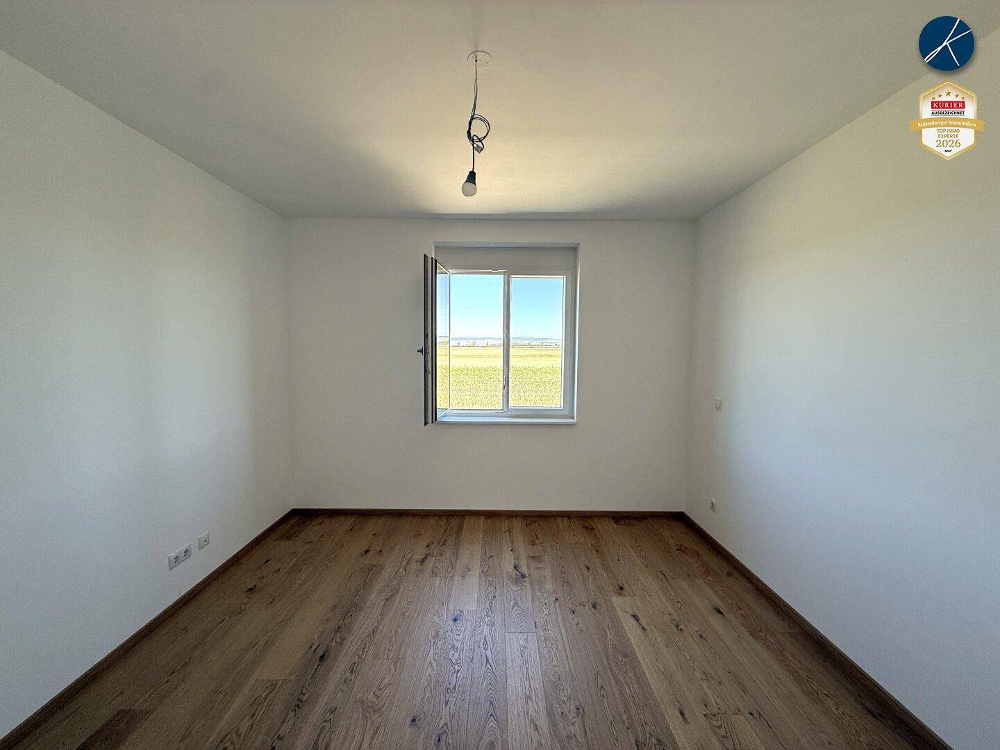 Helles Schlafzimmer mit Eichenparkett und weitem Blick über die Landschaft.