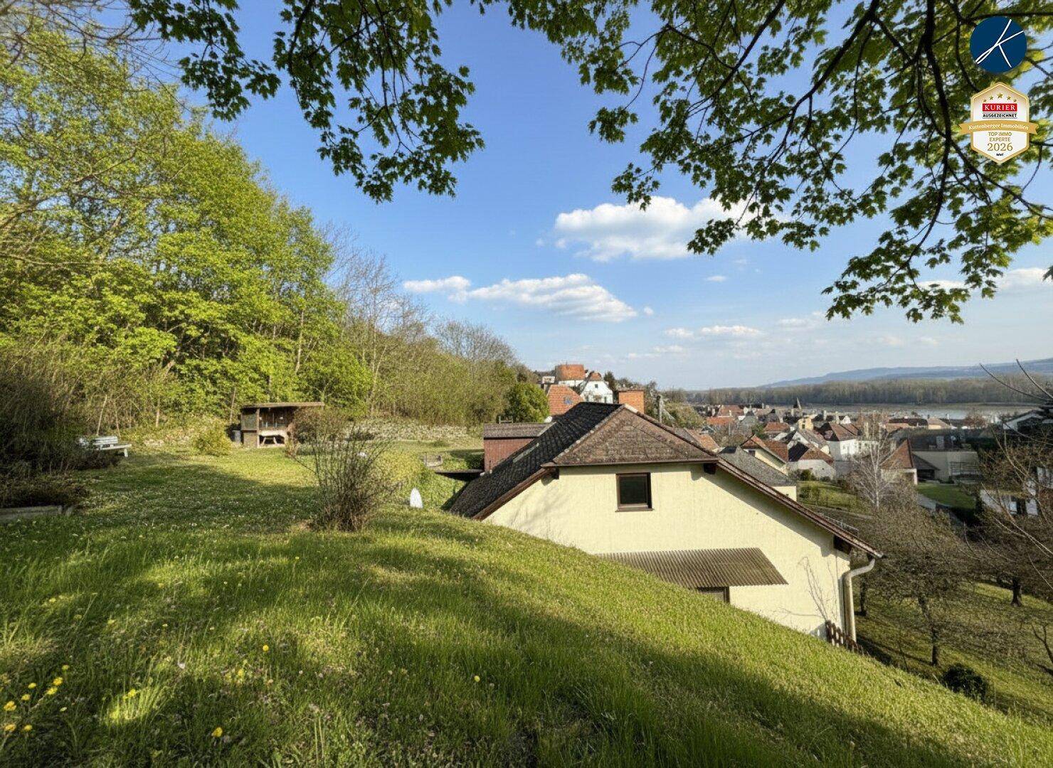 Weitläufiger Gartenbereich mit Rasenfläche und Blick auf das Haus sowie die umliegende Landschaft.