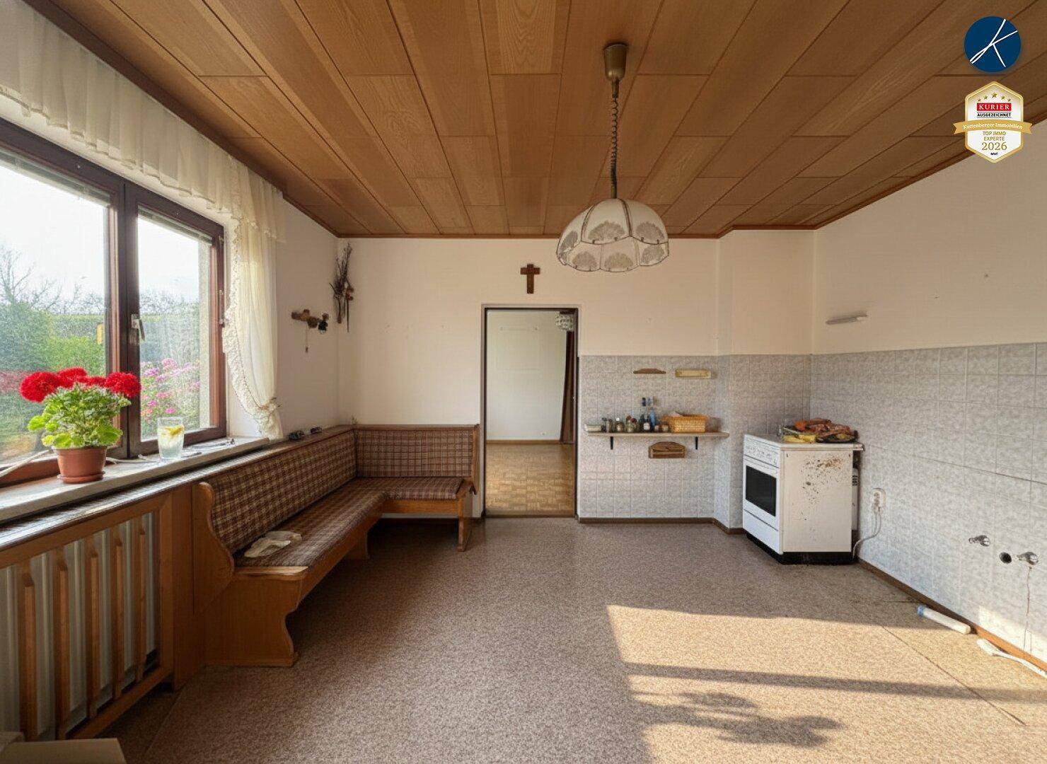 Geräumige Küche mit Essbereich, Holzdecke und einfacher Ausstattung, bereit zur Modernisierung.