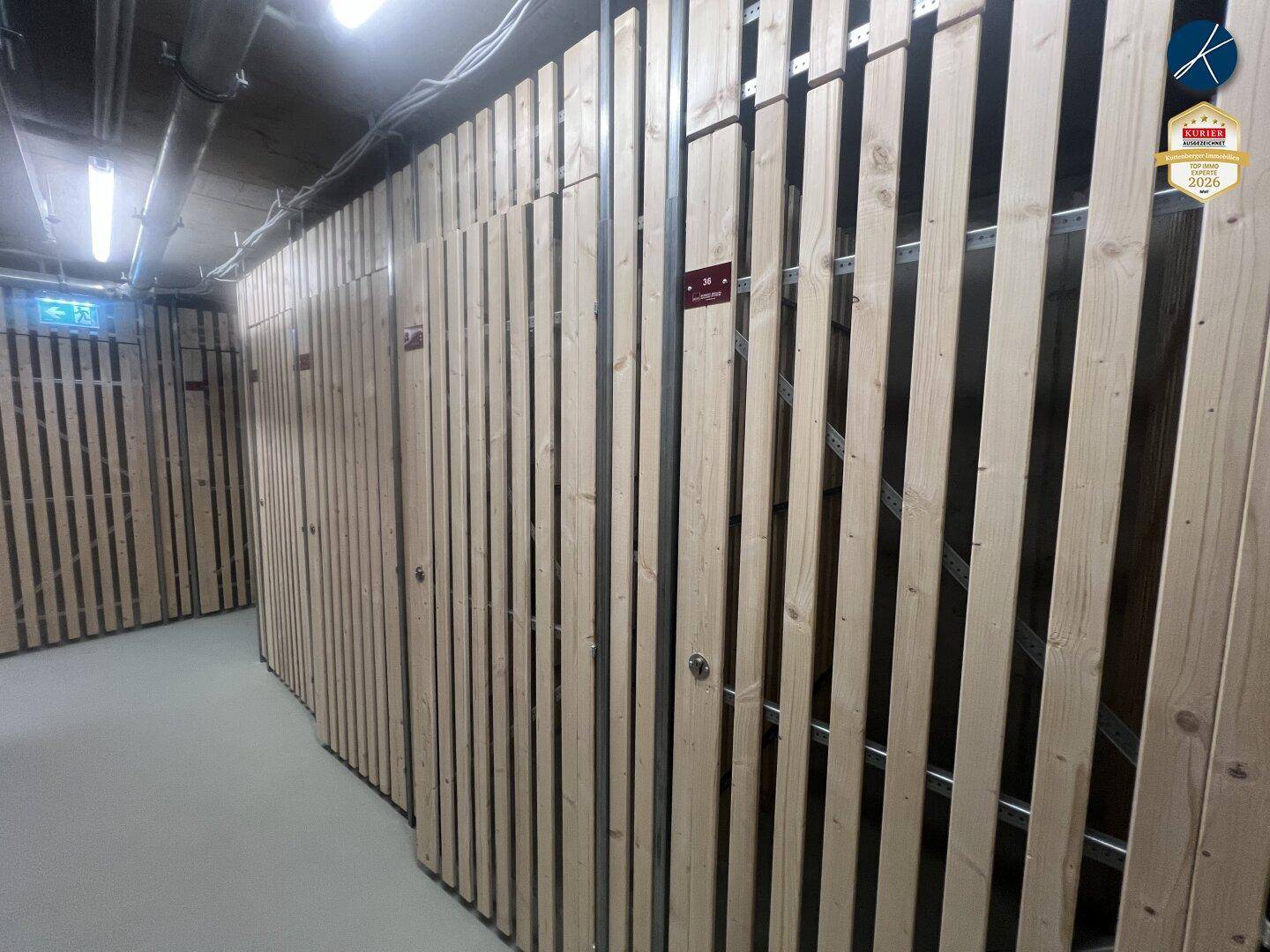 Reihe von Lagerräumen mit Holzlattenwänden in einem Gemeinschaftsbereich des Gebäudes.