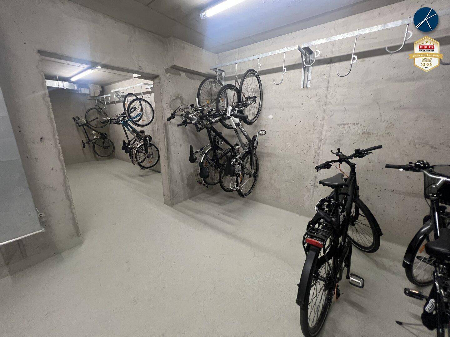 Fahrradraum mit mehreren Fahrrädern, die an Wandhalterungen aufgehängt sind.
