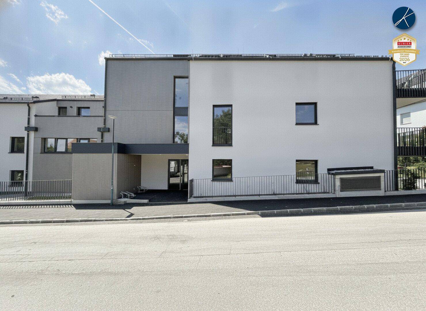 Vorderansicht des modernen Gebäudes von der Straße aus mit Eingangsbereich.