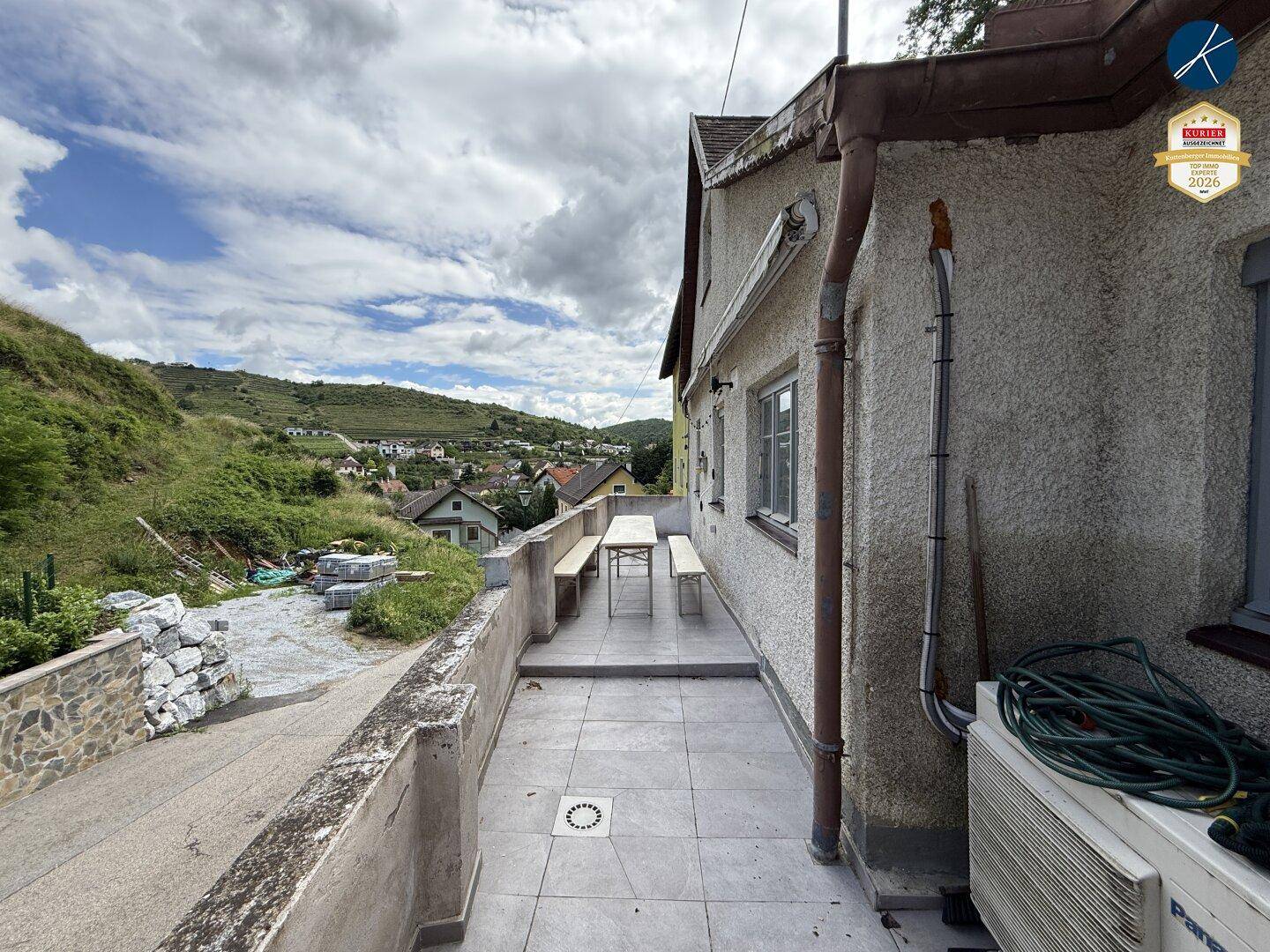 Terrasse mit Sitzgelegenheiten und weitem Blick auf die umliegenden Weinberge.