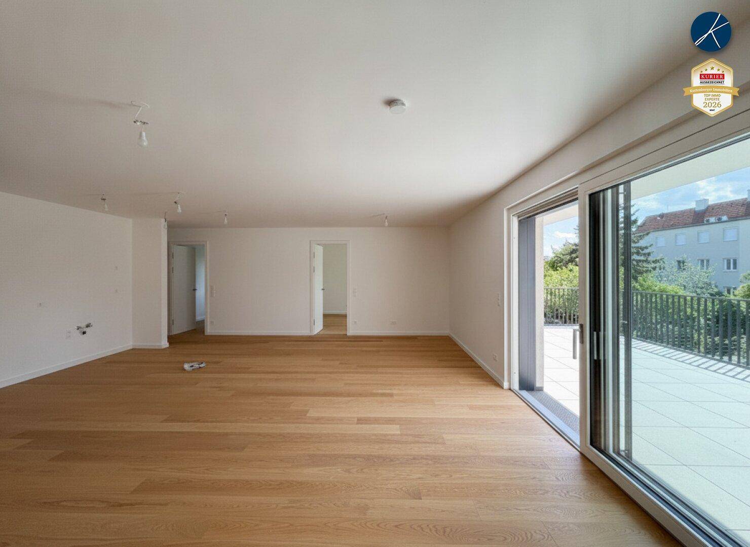 Helles, leeres Wohnzimmer mit Eichenparkett und großem Zugang zur Terrasse.