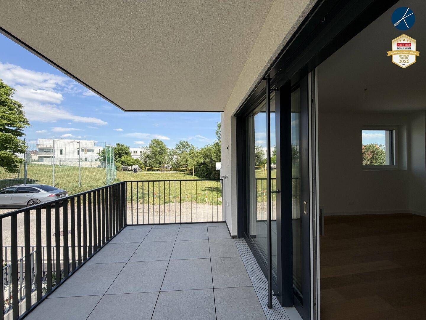 Geräumiger Balkon mit Fliesenboden und weitem Blick ins Grüne und auf die Umgebung.