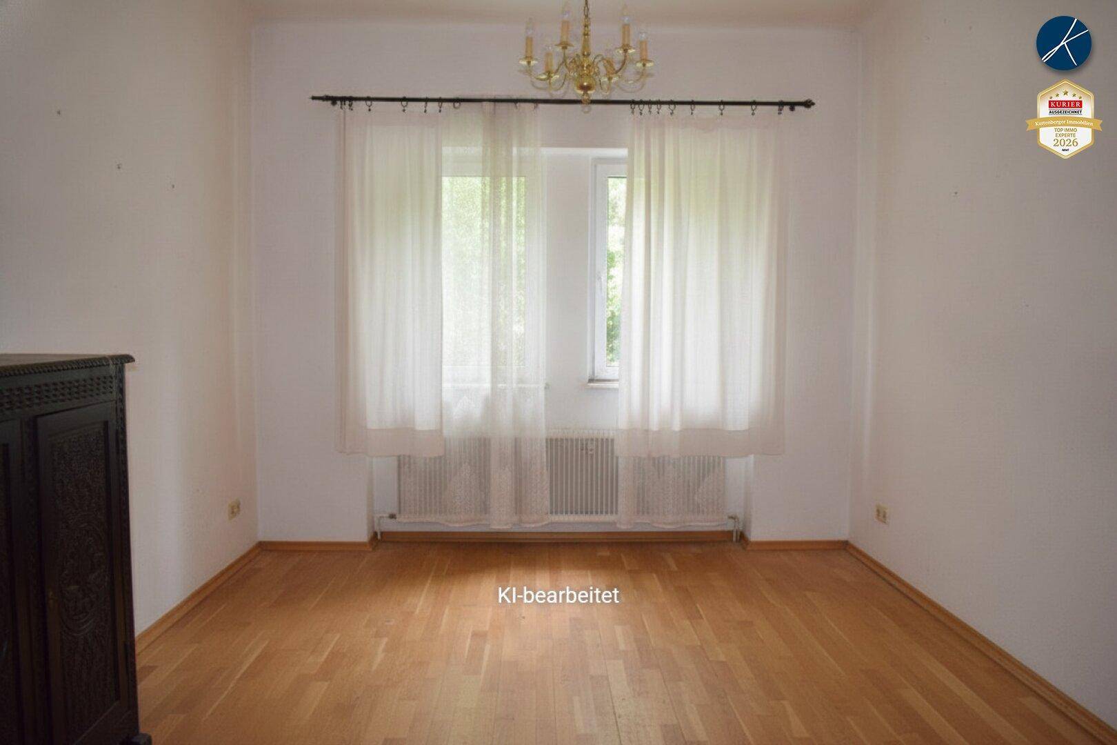 Leeres Zimmer mit Holzboden und großen Fenstern, bereit für individuelle Gestaltung.