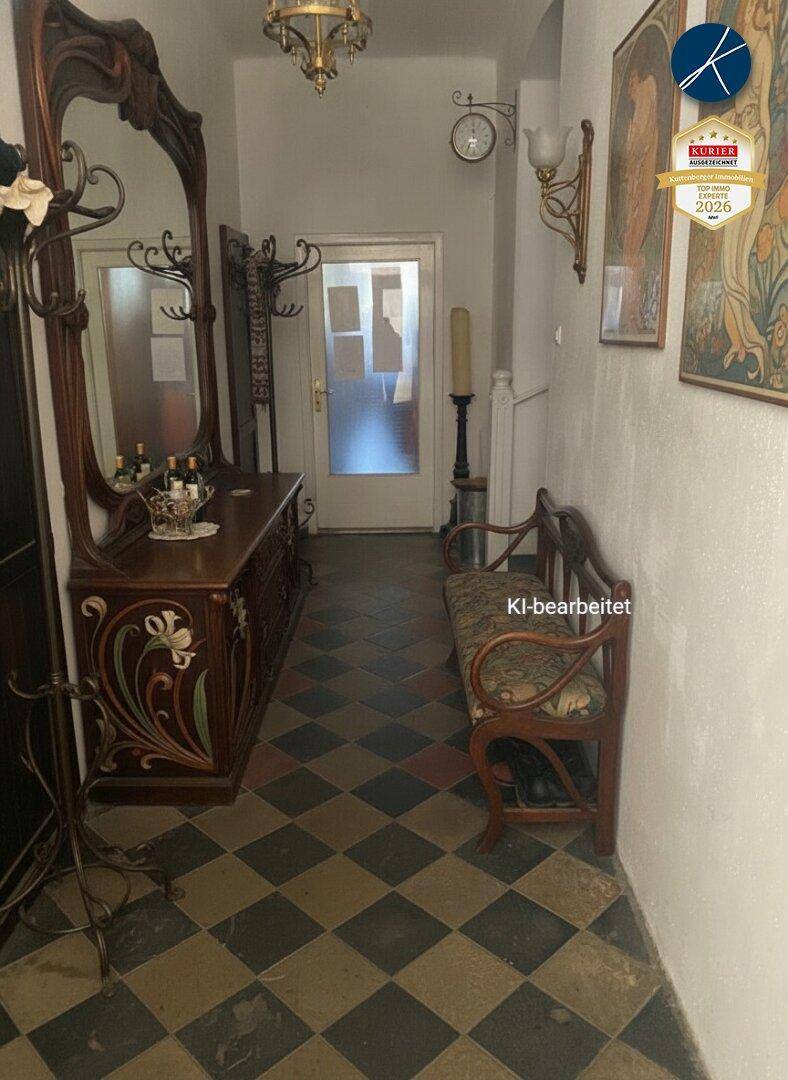 Geräumiger Flur mit gemusterten Fliesen, großer Spiegelgarderobe und Sitzbank.