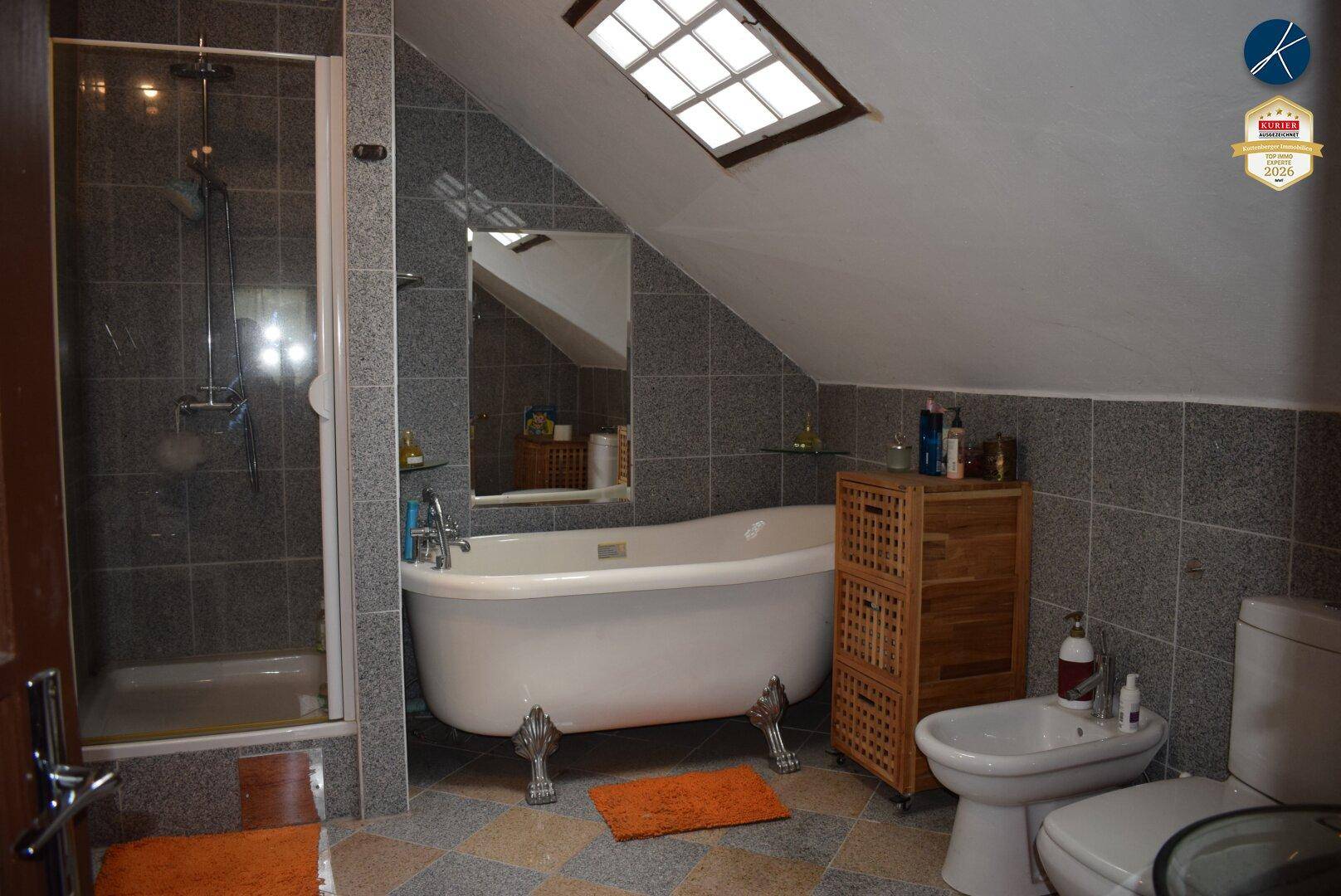 Modernes Dachgeschossbad mit freistehender Badewanne, Dusche und Dachfenster.