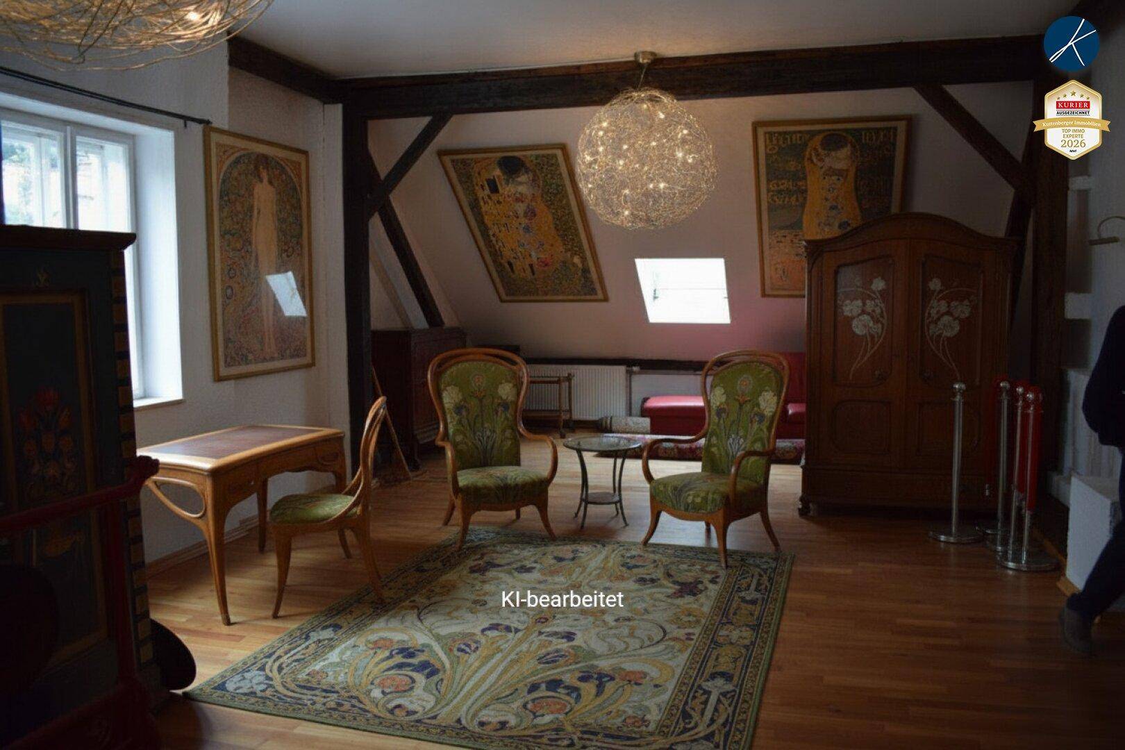 Großzügiger Wohnbereich im Dachgeschoss mit Holzbalken, Kunstwerken und gemütlichen Sesseln.