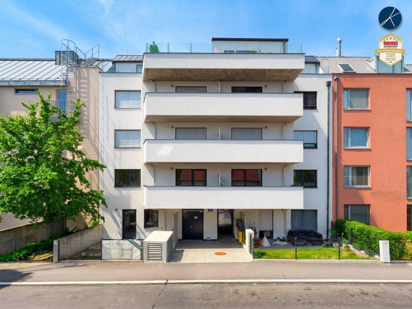 Ansicht der modernen Wohnhausfassade mit Balkonen und Zugang zum Gebäude.