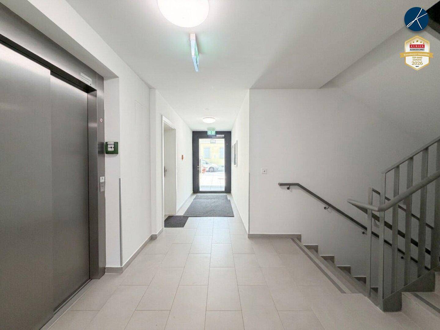 Langer, heller Flur mit Aufzug und Zugang zu den Wohneinheiten.