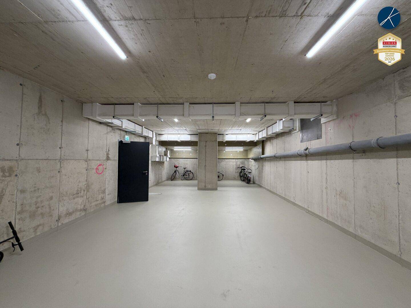 Geräumiger Kellerraum mit Betonwänden und Platz für Fahrräder.