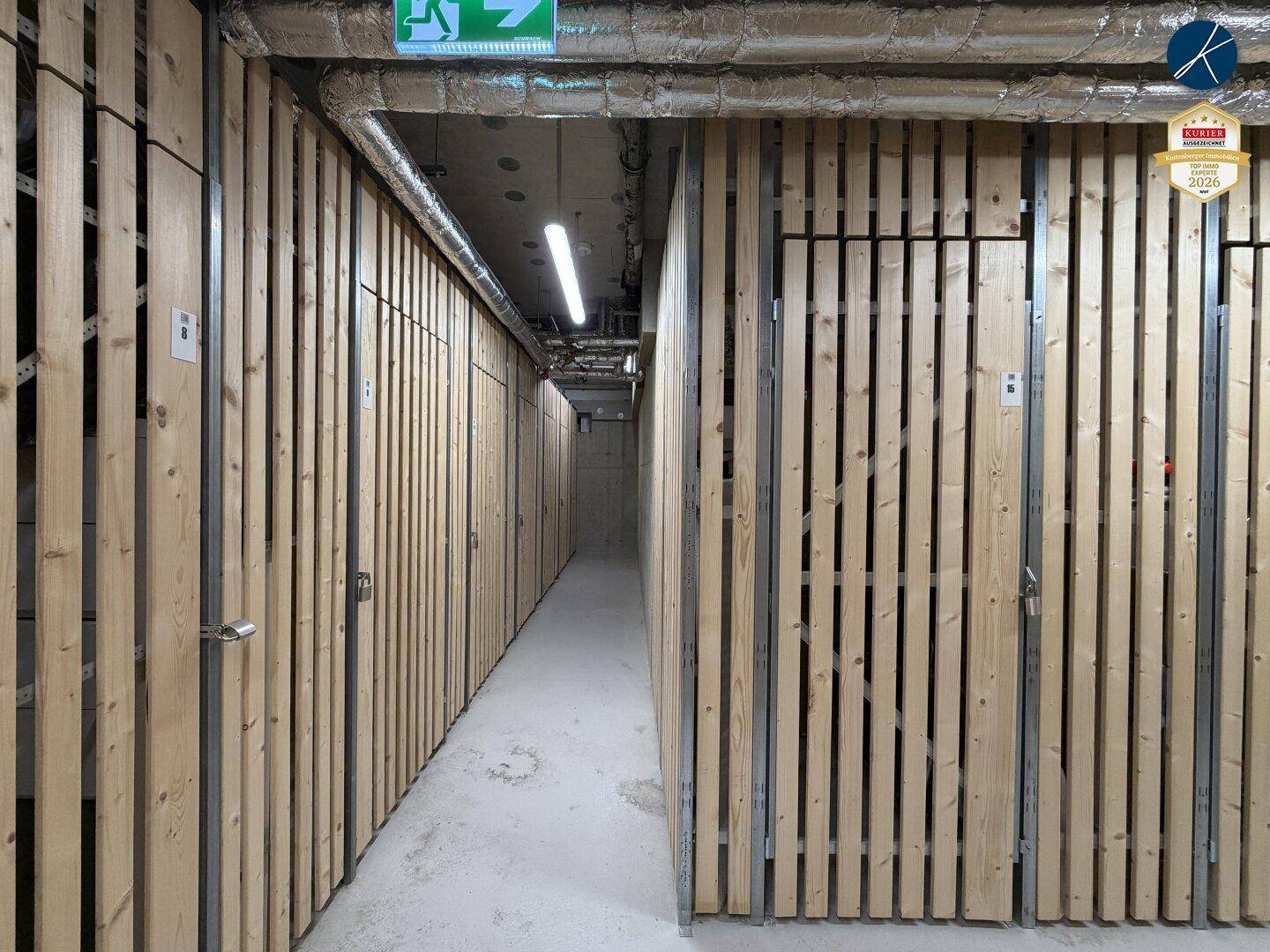 Reihe von abschließbaren Kellerabteilen mit Holzlamellenwänden.