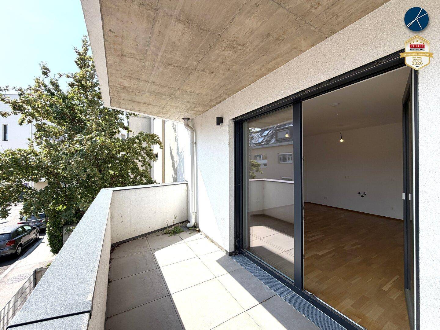 Sonniger Balkon mit Fliesenboden und Blick auf die Umgebung, ideal zum Entspannen im Freien.