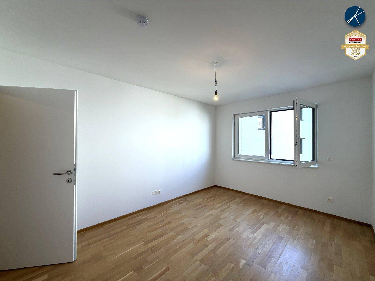 Schlafzimmer mit Parkettboden und weiß gestrichenen Wänden, bietet eine ruhige und helle Atmosphäre.