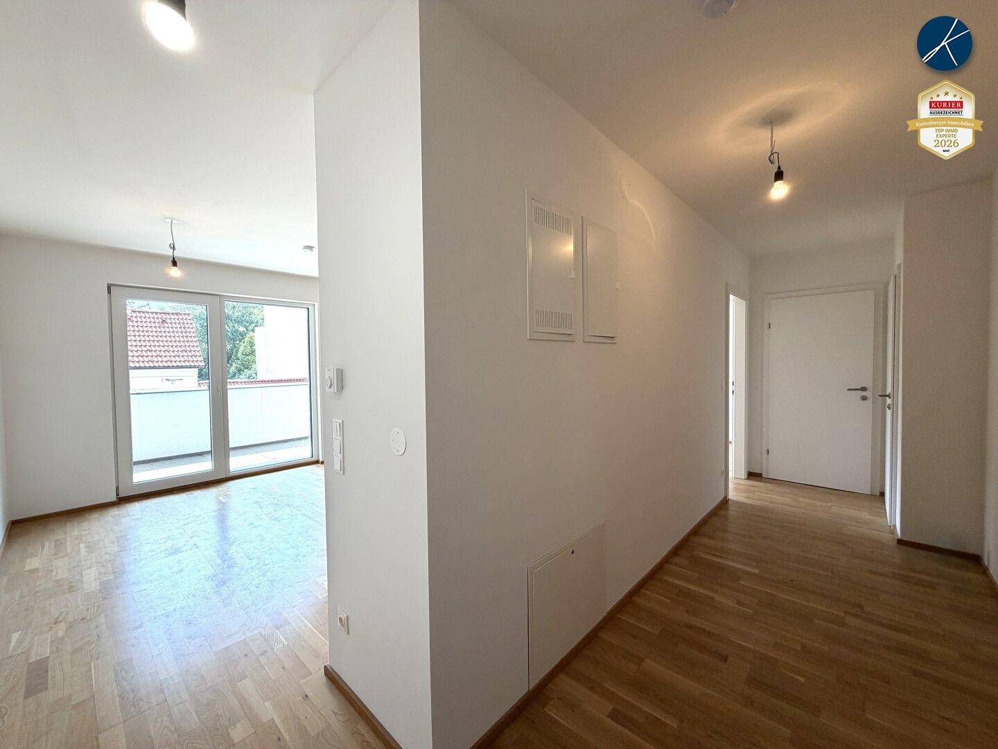 Heller Flur mit Parkettboden, der zu den verschiedenen Räumen der Wohnung führt und einen offenen Blick bietet.