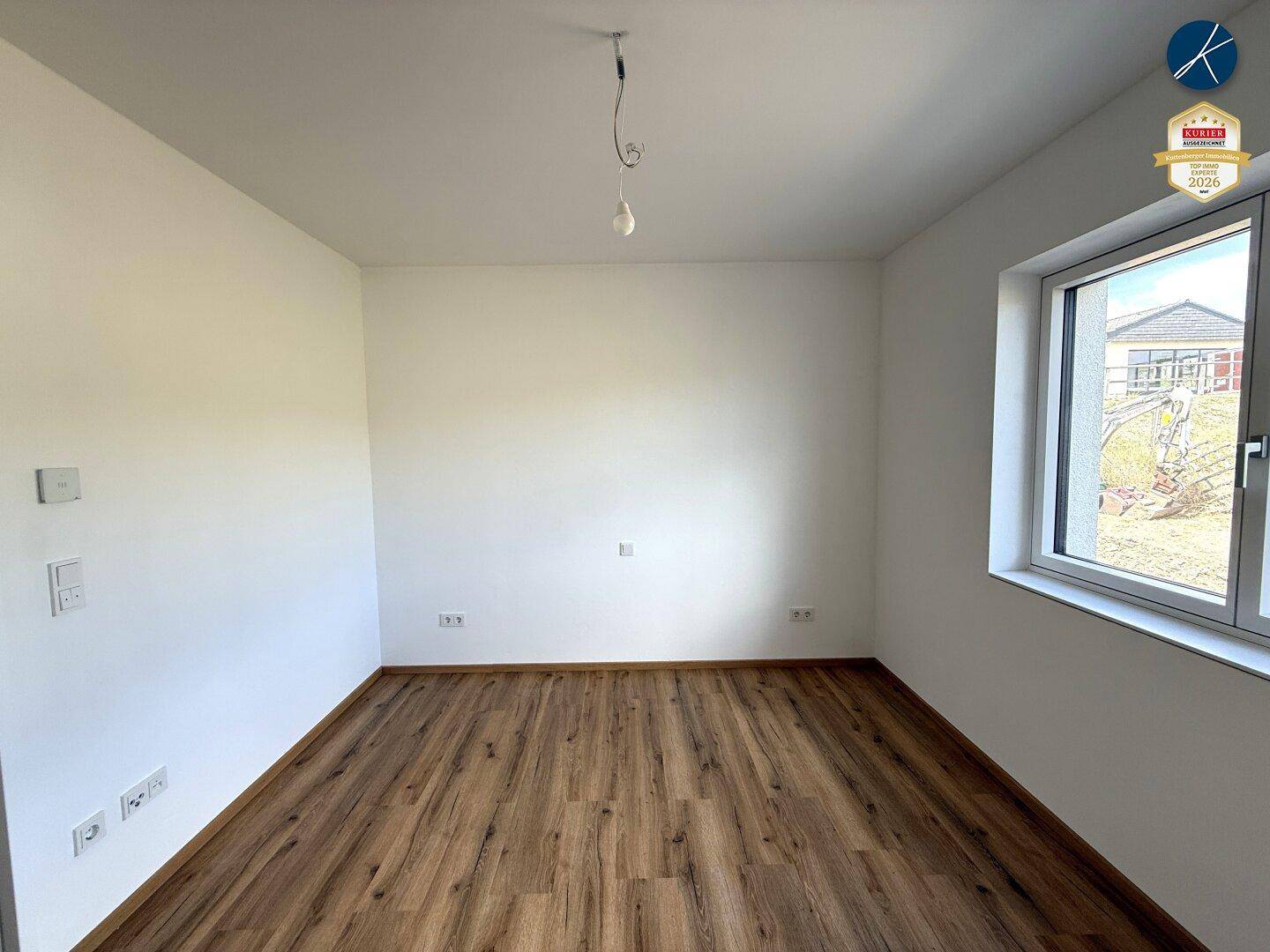 Ruhiges Zimmer mit Laminatboden und weiß gestrichenen Wänden, vielseitig nutzbar.
