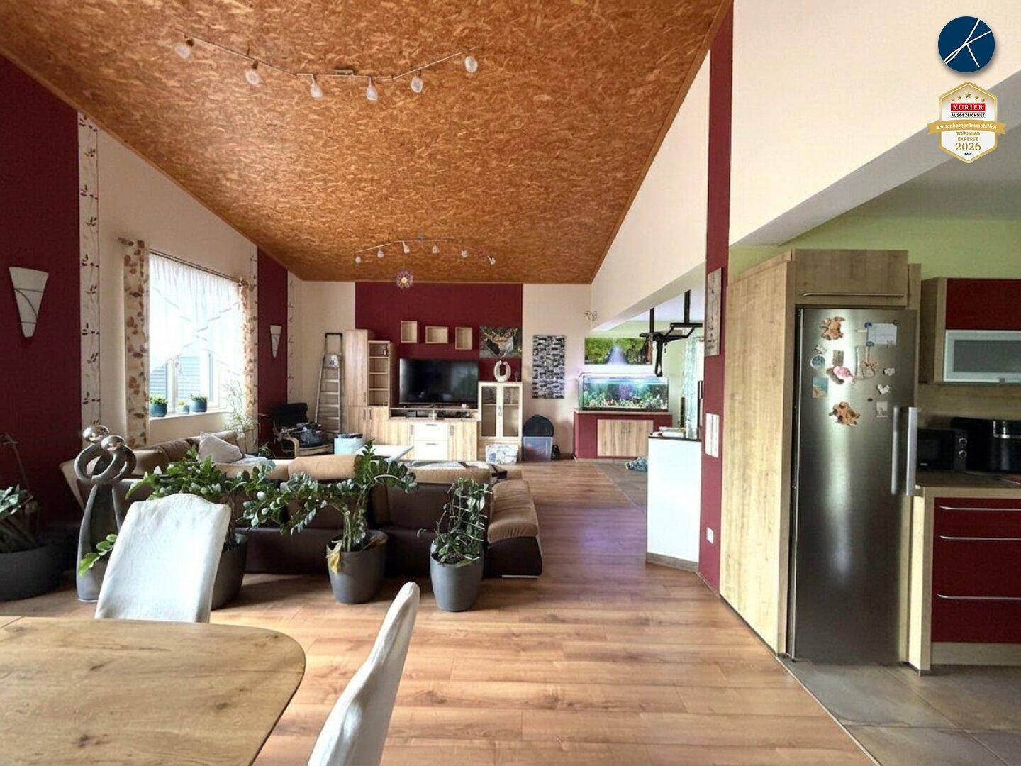Offener Wohn- und Essbereich mit Holzboden, OSB-Decke und moderner Einrichtung.