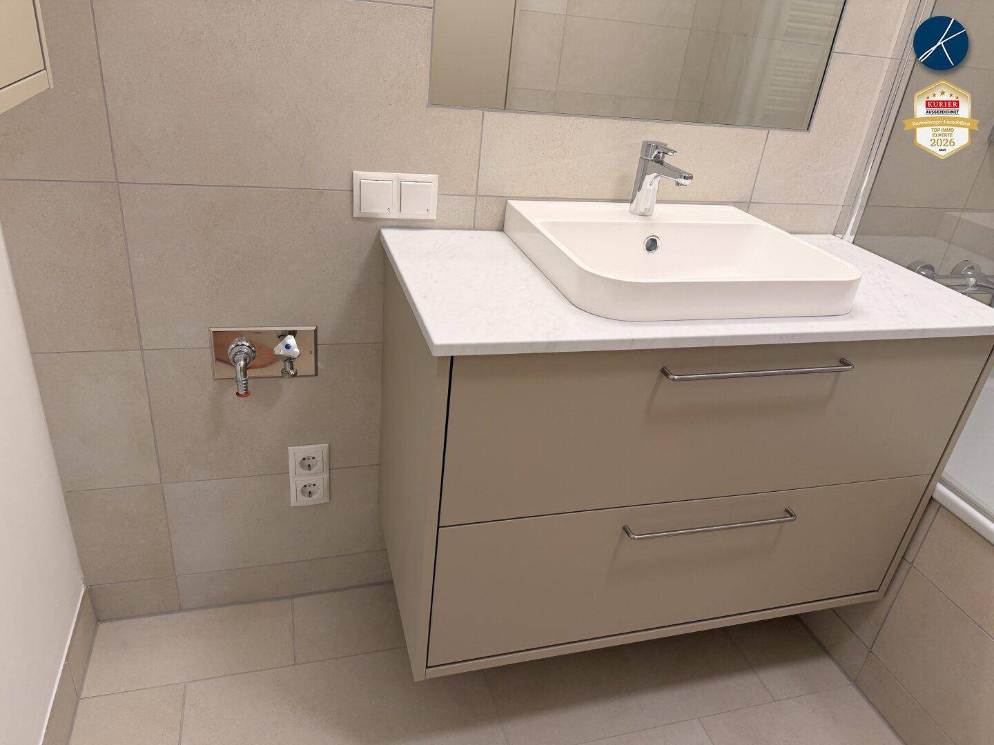 Moderner Waschtisch mit integriertem Waschbecken und Spiegel im Badezimmer.