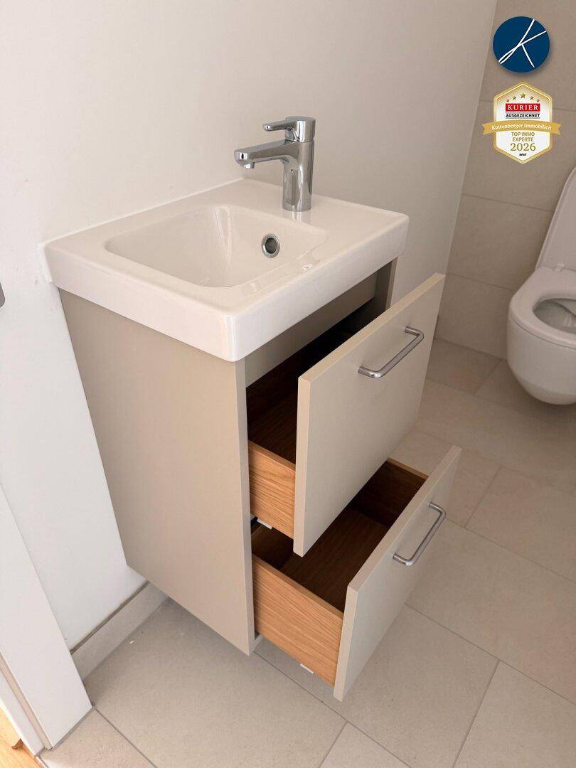 Kleiner Waschtisch mit Schubladen und wandhängendem WC in der Gästetoilette.