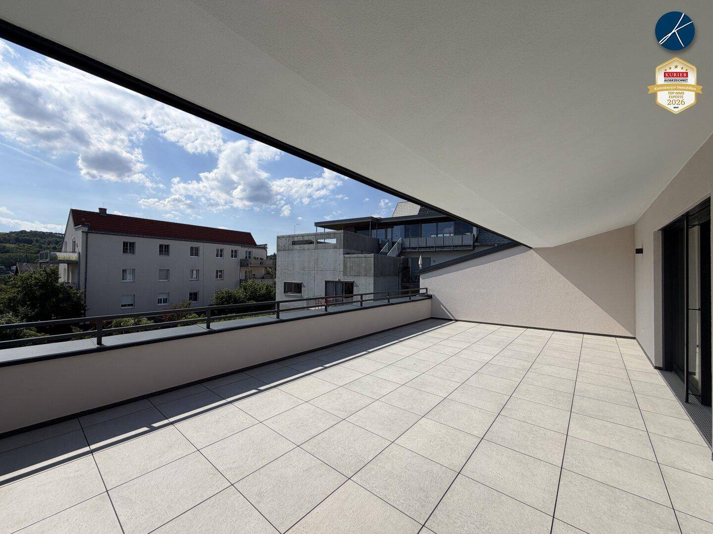 Geräumige Dachterrasse mit Fliesenboden und weitem Blick über die Nachbarschaft und die Umgebung.