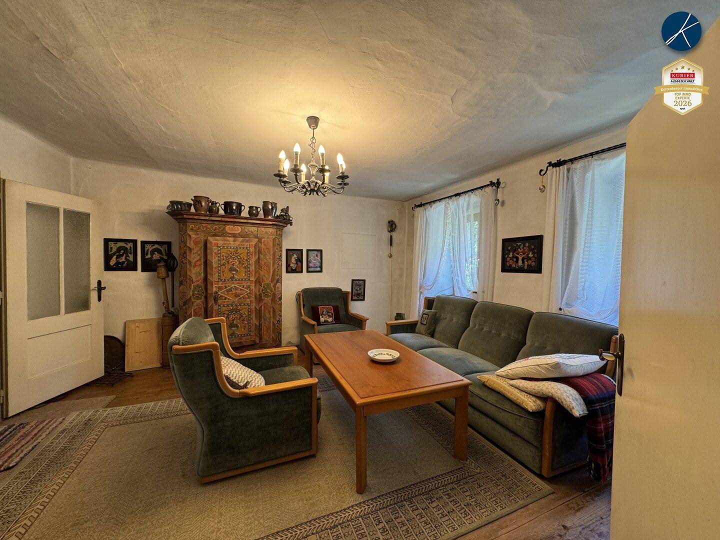 Geräumiges Wohnzimmer mit traditionellen Möbeln, Holzboden und Kronleuchter.